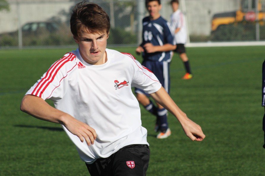 Grade 10 Michael Tilbury  attacks the ball with determination against a Notre Dame defender.