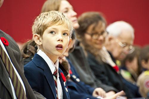 A junior school boy finds himself a seat prior to the service. 