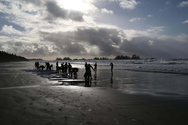 A beautiful picture of the boarders on the beach preparing to go surfing.