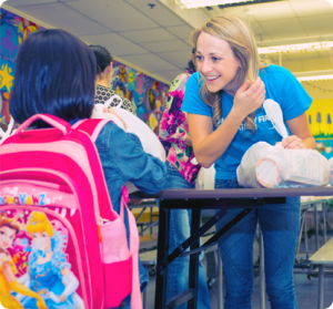 A Backpack Buddies volunteer socializes with a child. 