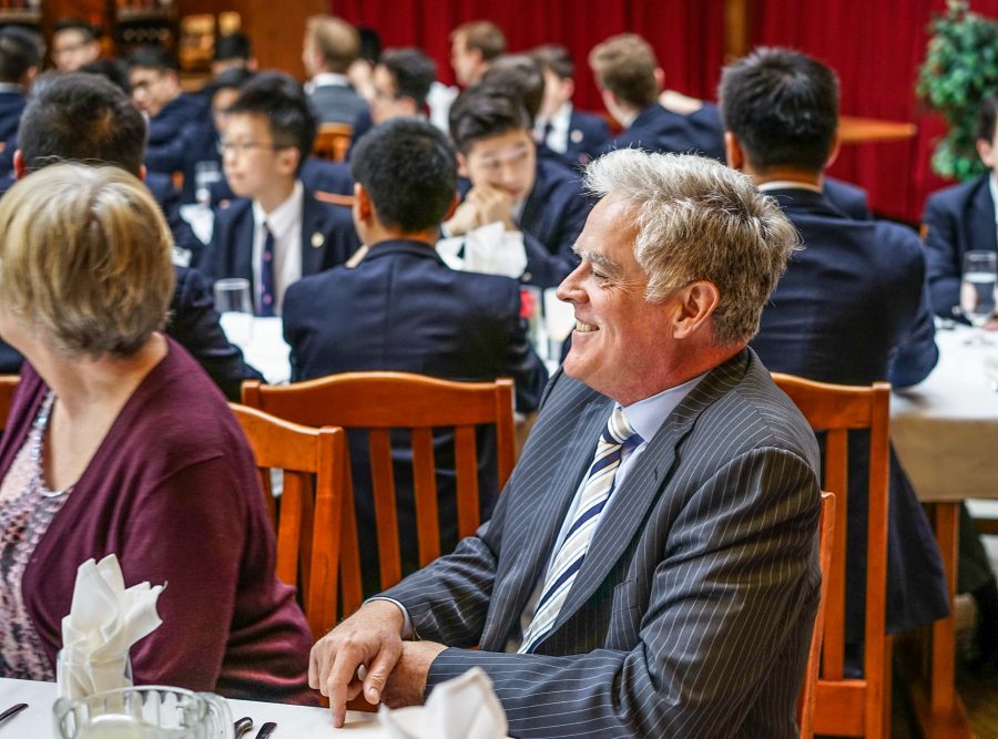 Headmaster Dr. T. Matthews observes the student performances at the Harker Hall Formal Dinner.