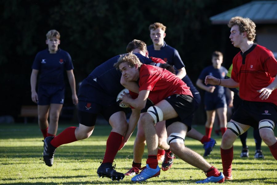 A speeding flanker falls to a 1st XV's iron-willed tackle.