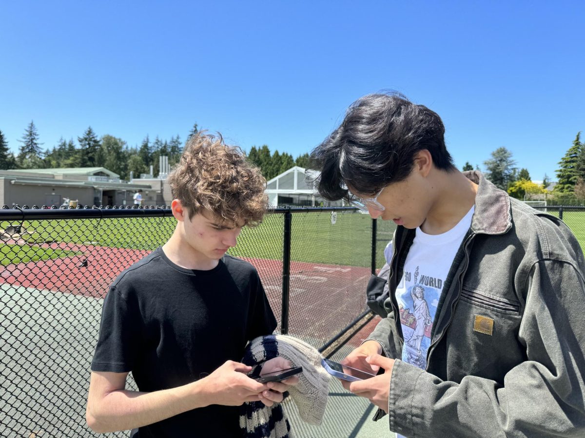 Students looking at their phone before a field trip